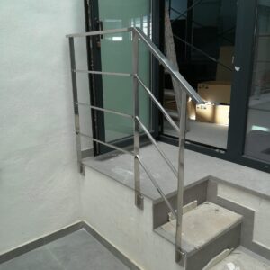 Elegantes barandillas de acero inoxidable y vidrio templado instaladas en un edificio de varias plantas. Diseño moderno, seguridad máxima y acabados de alta calidad en interiores y exteriores. Proyecto integral con forros decorativos de chapa de acero inoxidable en columnas