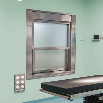 Ventana guillotina con apertura automatizada de ICMINOX instalada en quirófano, con vidrio plomado para protección de rediaciones y niveles de presión
