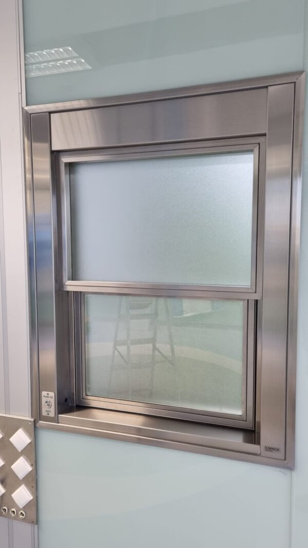 Ventana guillotina con apertura automatizada de ICMINOX instalada en quirófano, con vidrio plomado para protección de rediaciones y niveles de presión