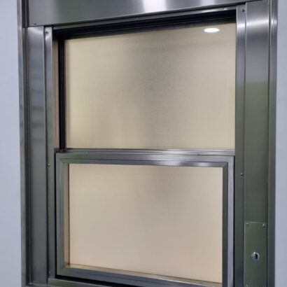 Ventana guillotina con apertura automatizada de ICMINOX instalada en quirófano, con vidrio plomado para protección de rediaciones y niveles de presión