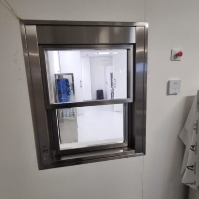 Ventana con vidrio plomado y apertura automatizada diseñadas para espacios clinicos