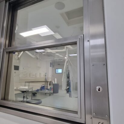 Ventana con vidrio plomado y apertura automatizada en espacios clinicos
