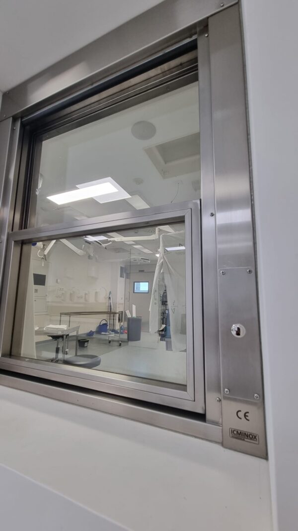 Ventana con vidrio plomado y apertura automatizada en espacios clinicos