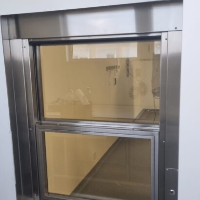 Ventana con vidrio plomado y apertura automatizada para espacios clinicos