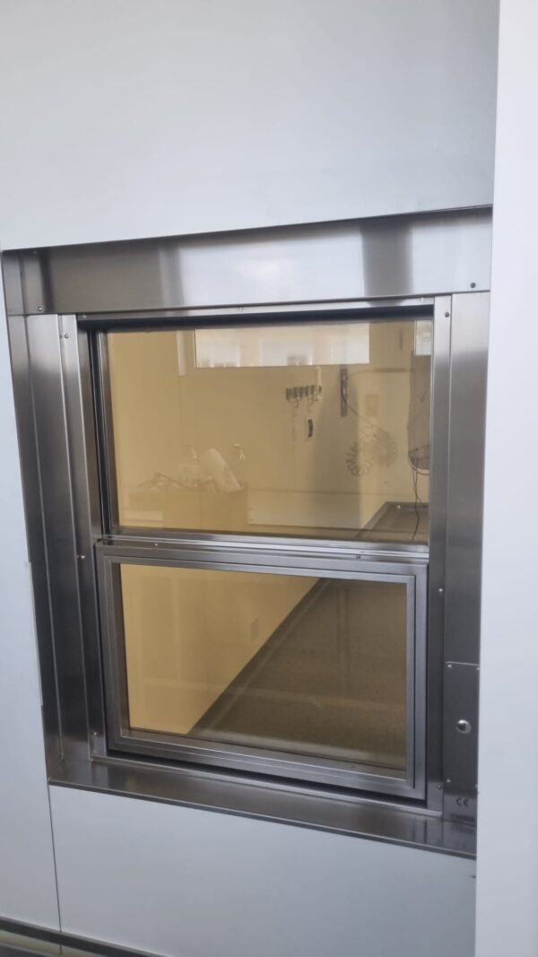 Ventana con vidrio plomado y apertura automatizada para espacios clinicos