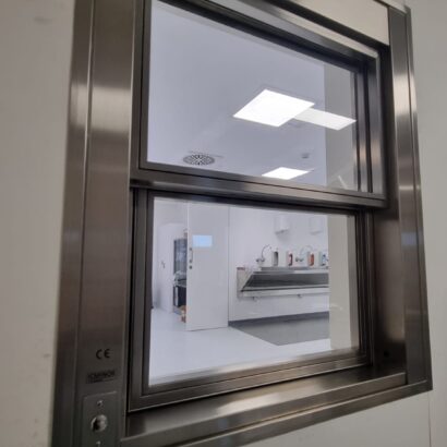 Ventana con vidrio plomado y apertura automatizada para espacios clinicos